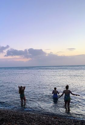 Girls swimming in the sea at sunrise