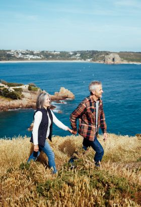 Couple walking on a cliff path above the sea