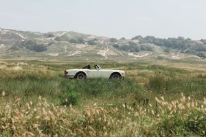 car driving in front of sand dunes