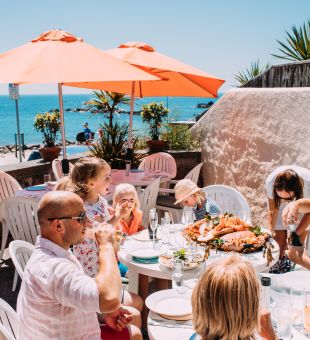 A family enjoying a seafood lunch on the terrace at Green Island Restaurant, Jersey