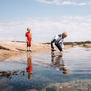 A lady rockpooling in Jersey at low tide