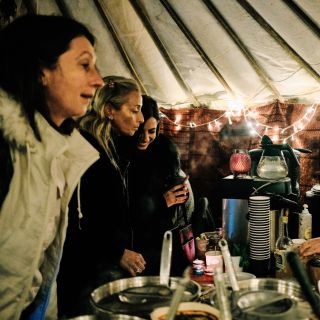 Inside of a yurt, customers buying mulled wine and cider