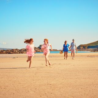 Family walking on Shell Beach, Herm