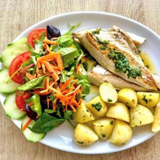 Plate of fresh fish, Jersey royals and salad