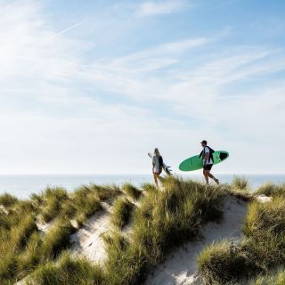 Surfers heading towards the water in St. Ouen