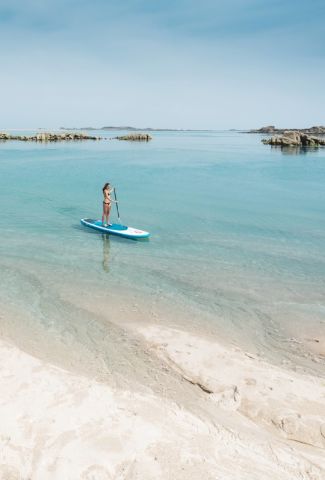 person paddle boarding in shallows