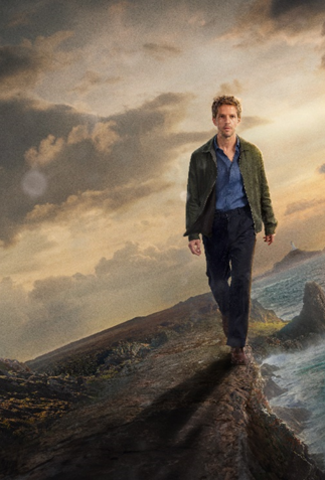 Damien Molony as Berrgerac walking along a cliff edge with the Radio Tower and Le Pinacle in the background.