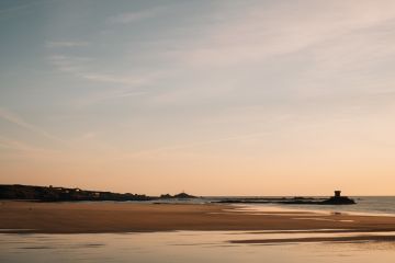 St Ouen's Bay at sunset with Rocco Tower and Corbiere Lighthouse in the background