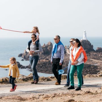 A family walking in front of Corbière Lighthouse