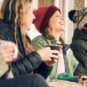 Group of friends lauging outside wearing winter clothes