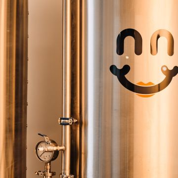 A picture of fermenting vats for beer with the Bliss Brew Co. Logo on it (the logo is a smile)