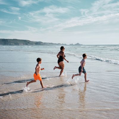 Family running into the sea