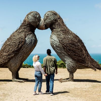 Young couple admiring the puffin sculptures at Plemont, Jersey
