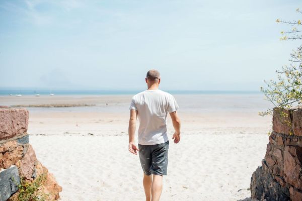 Man walking out onto beach