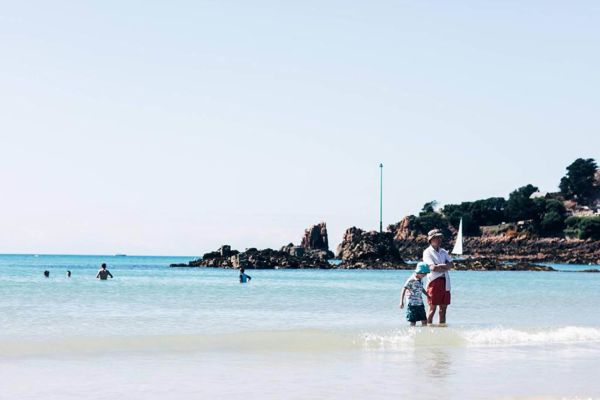People standing in the sea at St. Brelade