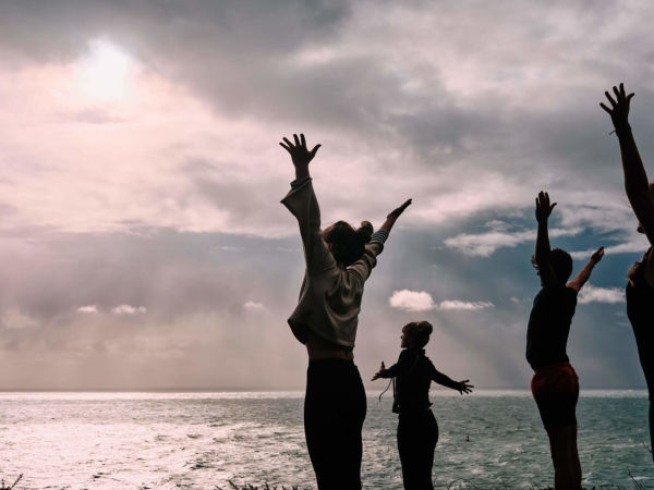 people doing yoga by the sea