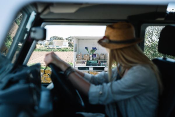 Woman driving and stopping at a farm stall