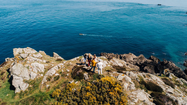 People standing on cliff path headland overlooking the sea