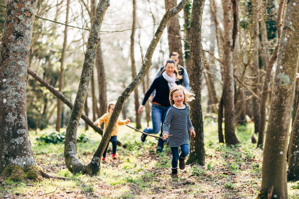 A family playing in woodlands in Jersey
