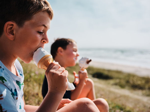 Two young boys eating Jersey Dairy Ice Cream by the beach