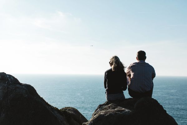couple sitting on the top of the cliff