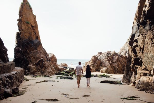 A couple walking among the rocks at Plemont Bay