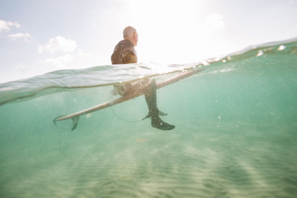 A man sitting on a surfboard in the sea