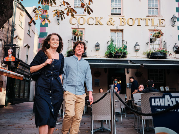 A couple walk past the Cock and Bottle Pub in St. Helier Jersey