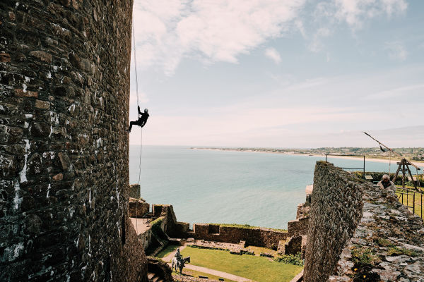 A person abseiling from Mont Orgueil Castle