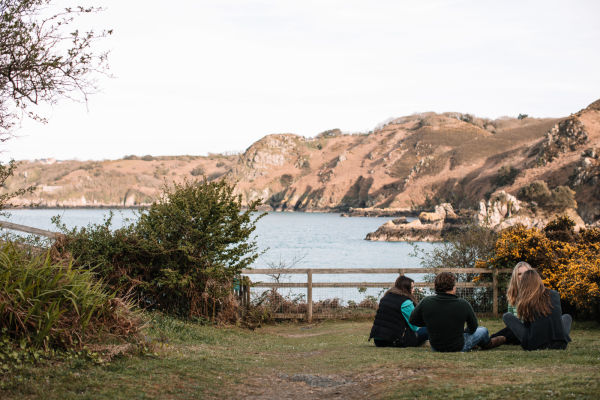 A group of young people sitting on the grass outside Fort Leicester