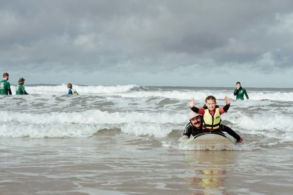 A group of children taking part in a Healing Waves surfing session at St. Ouen
