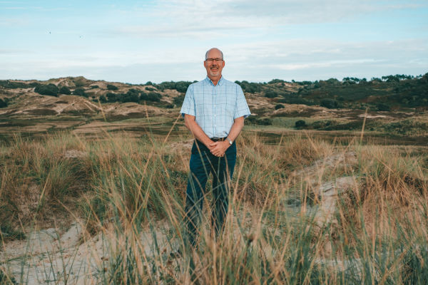 Jerry Neil standing in front of Sand dunes