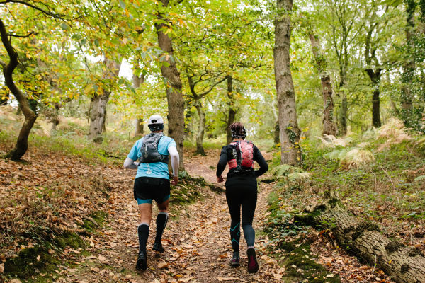 Couple running through the woods