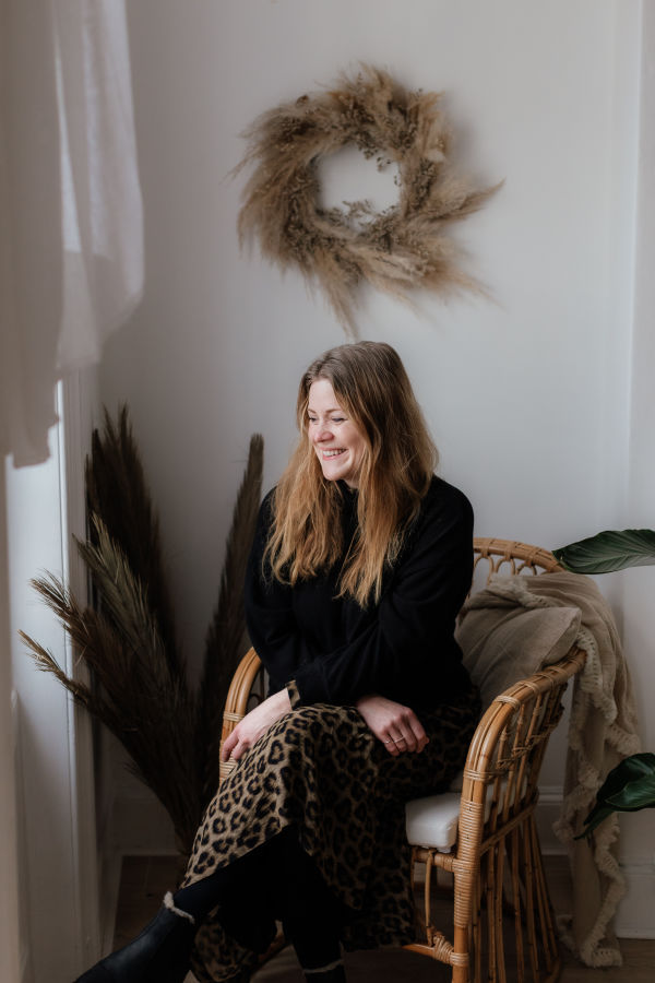 Blonde lady sitting in a chair and smiling