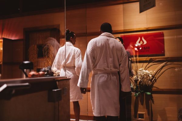 Couple walking in dressing gowns spa