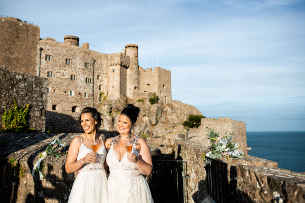 Two brides in front of a historic castle