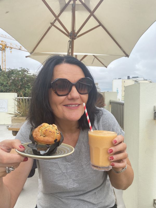 Woman holding muffin and juice