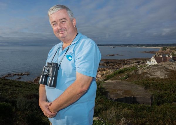 Roger Noel, Tour Guide with Jersey Uncovered standing in front of St. Ouen