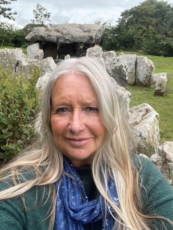 A photo of Amanda Band from Wild Edgewalker outside a Neolithic dolman in Grouville.