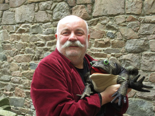 Man holding puppet smiling.