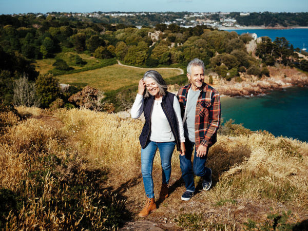 Couple walking on a headland by the sea in autumn