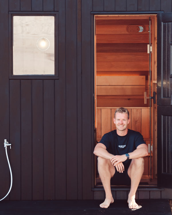 Young man sitting on the stairs of a sauna