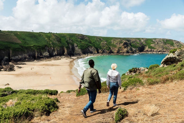 Young couple walking on the headland above Plemont Bay, Jersey