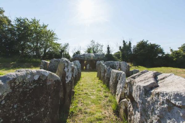 A picture of a Neolithic Dolmen in Jersey with sunshine and blue skies