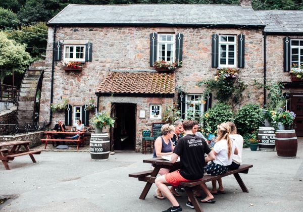 A family sitting at a table outside at the Moulin de Lecq pub