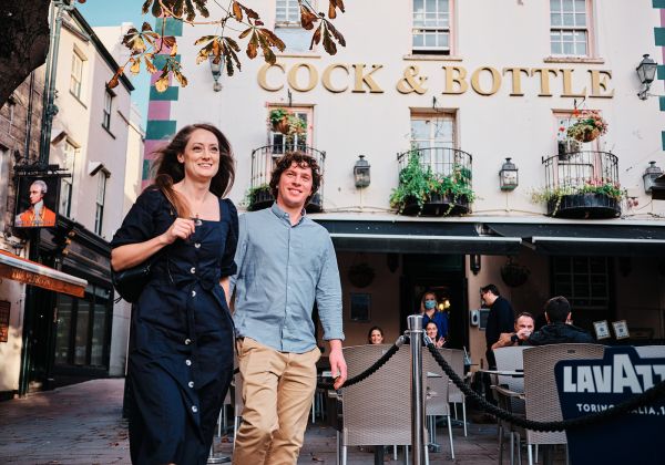 A couple walk past the Cock and Bottle Pub in St. Helier Jersey