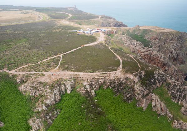 Group of people walking along a cliff path