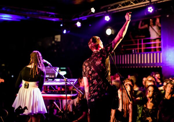 A band on stage at the watersplash performing to a full crowd.