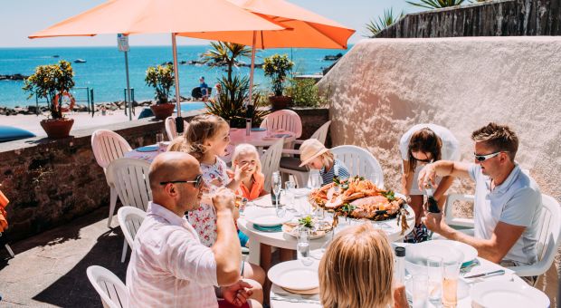 A family enjoying a seafood lunch on the terrace at Green Island Restaurant, Jersey