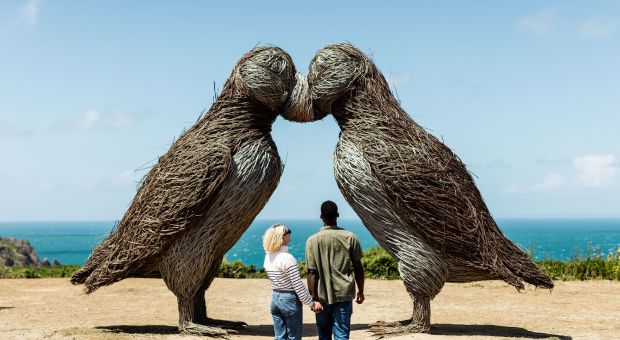 Young couple admiring the puffin sculptures at Plemont, Jersey